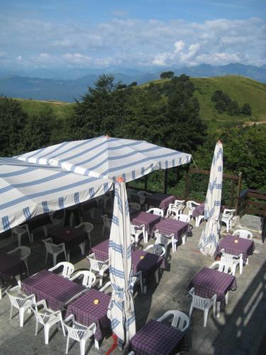 een groep tafels en stoelen met parasols bij Albergo Casa Della Neve in Stresa