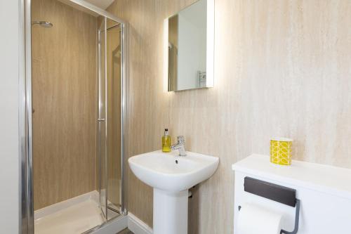 a white bathroom with a sink and a shower at 3 Porthminster B&B in St Ives