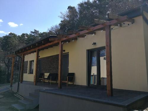 a pergola on the side of a house at Domek przy lesie in Gdańsk