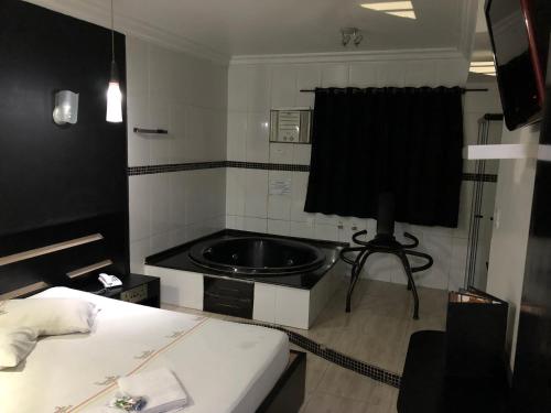 uma casa de banho com um lavatório no meio de um quarto em Hotel Romance (Adults Only) em São Paulo