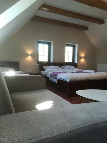 a bedroom with two beds and a couch and windows at Stara Kuźnia Mazurska in Węgorzewo