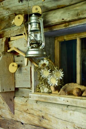 a bell is hanging from a wooden wall with flowers at Hotel Gretina in Bezau