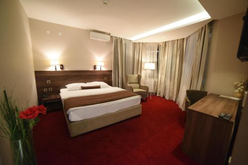 a hotel room with a bed and a desk at Hotel Bavka in Leskovac