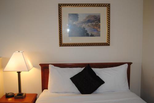 a bedroom with a bed with a picture on the wall at Economy Inn in Edmonton