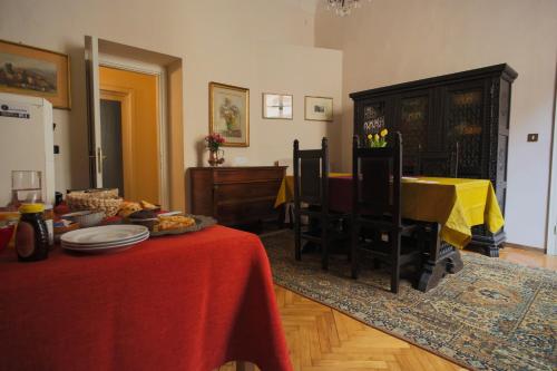 sala de estar con mesa y mantel rojo en B&B Palazzo Malaspina, en Piacenza