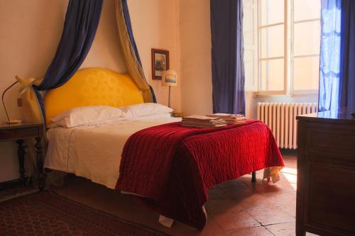 a bedroom with a bed with a red blanket at B&B Palazzo Malaspina in Piacenza