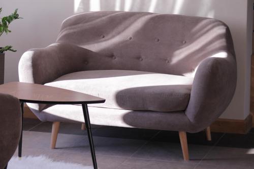 a chair in a living room with a table at Willa Królewska - Wellness SPA - widokowe Pokoje i Apartamenty in Kościelisko