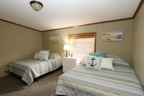 a bedroom with two beds and a window at Island Club Rentals in Put-in-Bay
