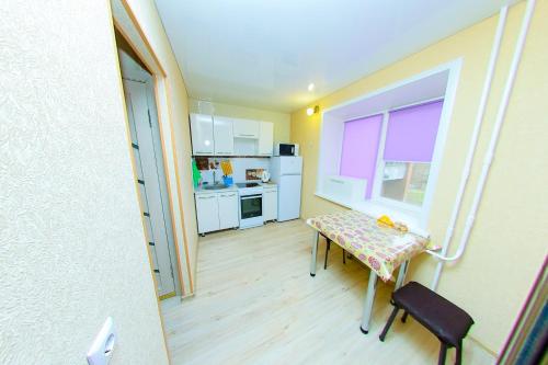 ein kleines Zimmer mit einem Tisch und einer Küche in der Unterkunft Apart on Slavskogo 14 in Öskemen