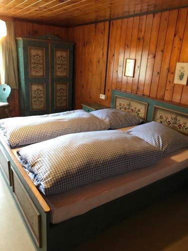 two beds in a room with wooden walls at Bergstätt Lodge in Immenstadt im Allgäu