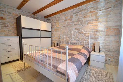 una camera da letto con un letto e un muro di pietra di Villa Giardin a Novigrad Istria
