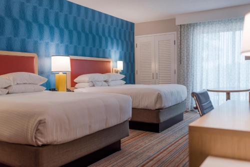 a hotel room with two beds and a table at Howard Johnson by Wyndham Anaheim Hotel & Water Playground in Anaheim