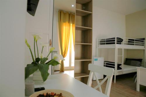 a kitchen with a table and a room with a bunk bed at Andolfi 24 Rooms in Pompei