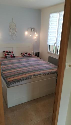 - une chambre avec un lit et une couette à rayures dans l'établissement Les Hauts De Reillanne, à Reillanne