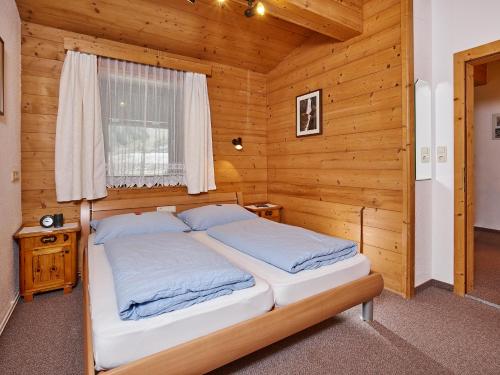 1 dormitorio con 1 cama en una habitación de madera en Appartementhaus Staff, en Niederthai