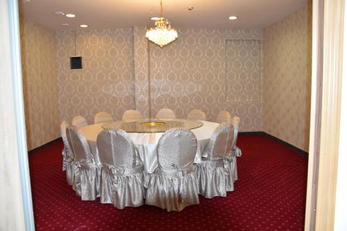 a dining room with a table with chairs and a chandelier at Hotel & Restaurant Great Wall - Airport in Sarajevo