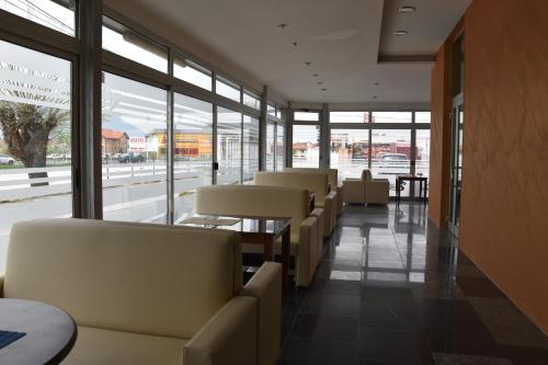a row of chairs in a waiting room with windows at Hotel & Restaurant Great Wall - Airport in Sarajevo