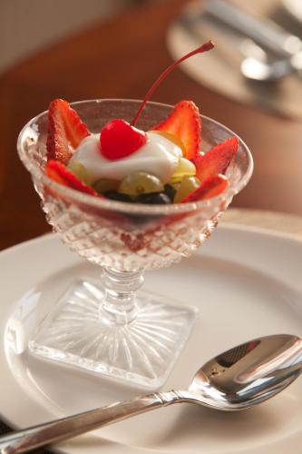 a glass bowl with fruit and whipped cream on a plate at Andon-Reid Inn Bed & Breakfast in Waynesville