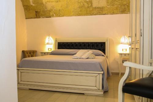 Palazzo Piccioli في غالّيبولي: غرفة نوم بسرير كبير مع مواقف ليلتين