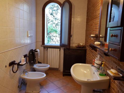 a bathroom with two toilets and a sink and a window at La Limonaia in Castel Volturno