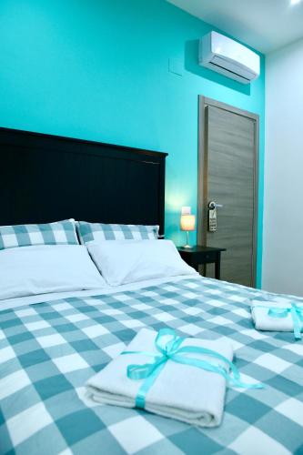a blue bedroom with a bed with towels on it at Andolfi 24 Rooms in Pompei