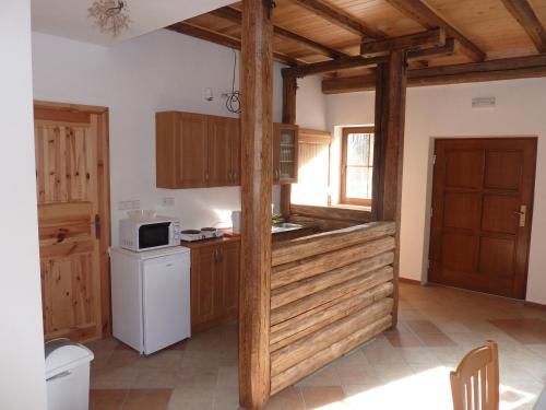 uma cozinha com armários de madeira e um frigorífico branco em Ubytování Podolí U Křížku em Telč