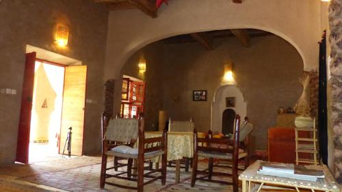 una sala da pranzo con tavolo e sedie in una stanza di Riad Tabhirte a Agdz