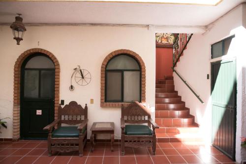 a porch of a house with two chairs and stairs at Hotel María Elena in Durango