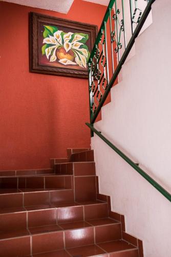 a stairway with a painting on the wall and a stair case at Hotel María Elena in Durango