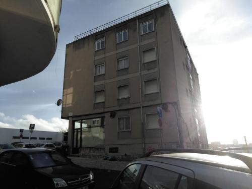 a tall building with cars parked in front of it at Voyage 63 in Lisbon