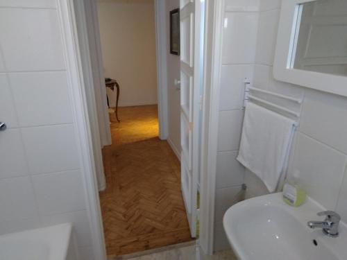 a white bathroom with a sink and a mirror at Voyage 63 in Lisbon