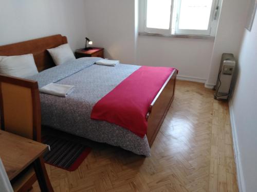 a bedroom with a large bed with a red blanket at Voyage 63 in Lisbon