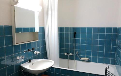 サンモリッツにあるAllod Bad 104の青いタイル張りのバスルーム(シンク、シャワー付)
