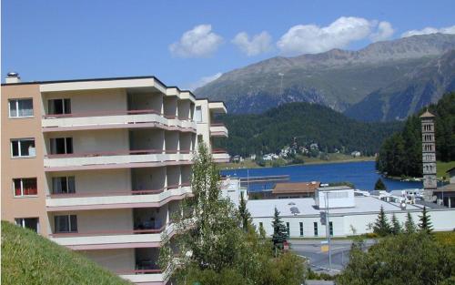 um edifício de apartamentos com vista para um lago e montanhas em Allod Bad 203 em St. Moritz