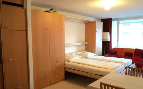 um pequeno quarto com uma cama e um armário em Allod Bad 203 em St. Moritz