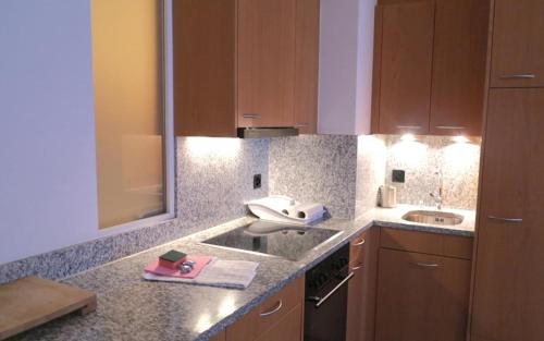 uma cozinha com um lavatório e uma bancada em Allod Bad 203 em St. Moritz