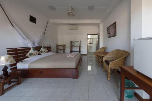 a bedroom with a bed and a table and chairs at BABA Guesthouse in Don Det