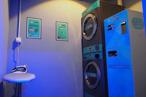 a blue room with a washing machine and a stool at Space Hotel @ Chinatown Kuala Lumpur in Kuala Lumpur
