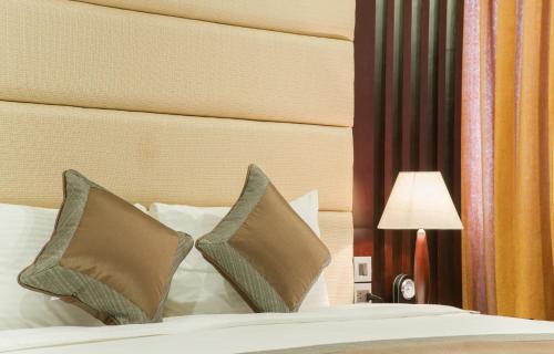 a bedroom with a bed with pillows and a headboard at Muong Thanh Hanoi Centre Hotel in Hanoi