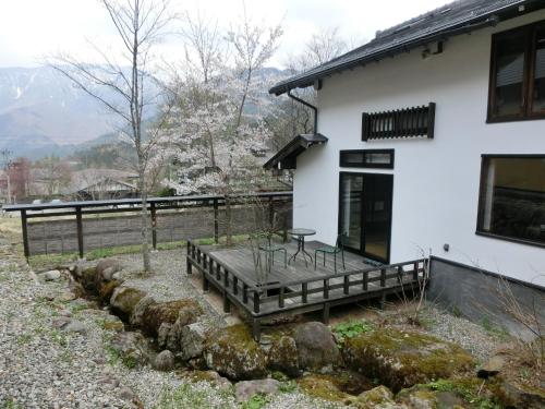 a white house with a bench in front of it at Katsuragi no Sato in Takayama