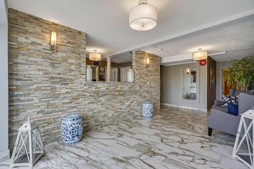 a living room with a stone wall and a couch at Blue Creek Inn in Waretown