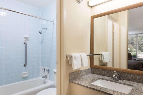La salle de bains est pourvue d'un lavabo, d'une baignoire et d'un miroir. dans l'établissement Super 8 by Wyndham Hope, à Hope