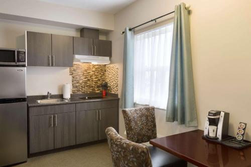 a small kitchen with a table and a kitchen gmaxwell gmaxwell gmaxwell gmaxwell gmaxwell at Travelodge by Wyndham Kindersley in Kindersley