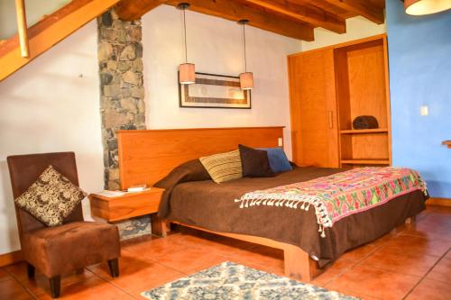 1 dormitorio con 1 cama y 1 silla en Monterra Tapalpa, en Tapalpa