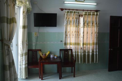 a room with two chairs and a table and a television at Minh Ha Hotel in La Gi