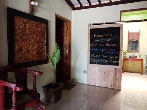 a chalkboard on the wall in a room with a table at Arjuna Garden Homestay in Yogyakarta