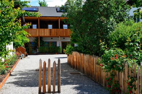 a house with a wooden fence and a garden at Apartments Mitterhof 1544 in Brunico