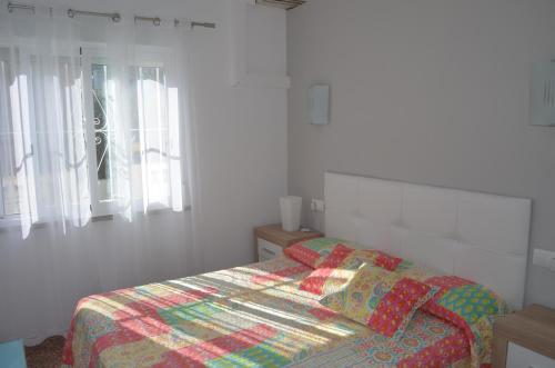 デニアにあるLa sirenitaのベッドルーム1室(カラフルなキルトのベッド1台付)