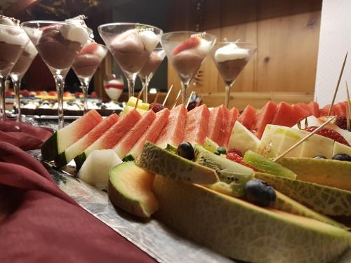 a table with a bunch of fruit and wine glasses at Hotel Alt Wittower Krug in Wiek auf Rügen 