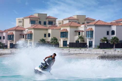 a man riding a jet ski in the water at The Grove Resort Bahrain in Manama